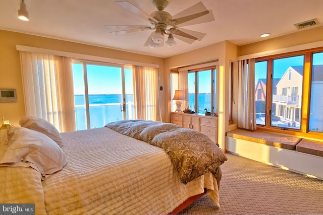 carpeted bedroom with visible vents, ceiling fan, and access to outside