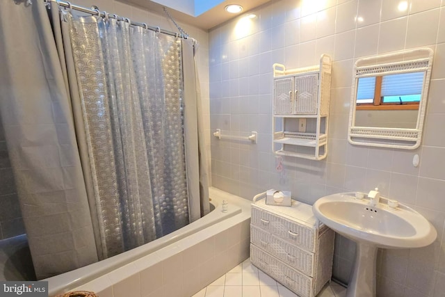 bathroom with tile patterned flooring, backsplash, tile walls, and tiled shower / bath