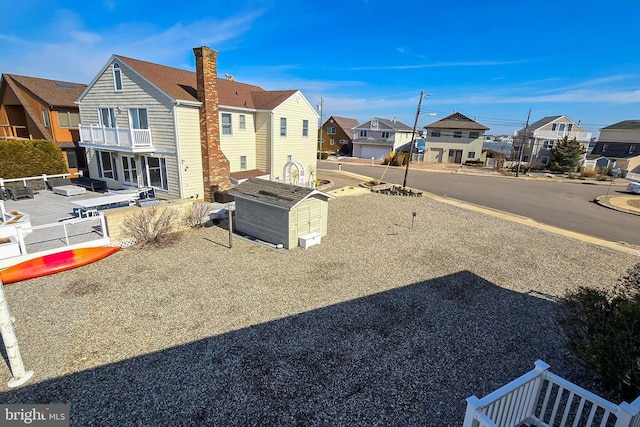 view of yard featuring a residential view, a balcony, and fence