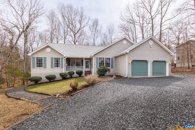 ranch-style house with gravel driveway, a front yard, a garage, and covered porch