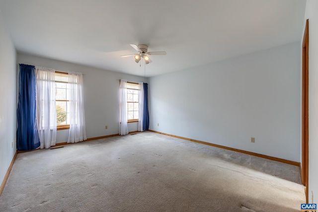 spare room featuring light carpet, visible vents, baseboards, and a ceiling fan