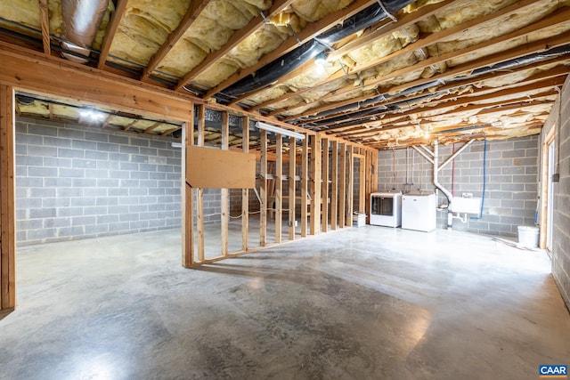 unfinished basement with washer and clothes dryer and a sink