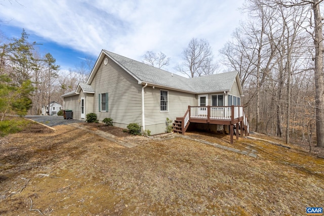 view of home's exterior featuring a deck and a shingled roof