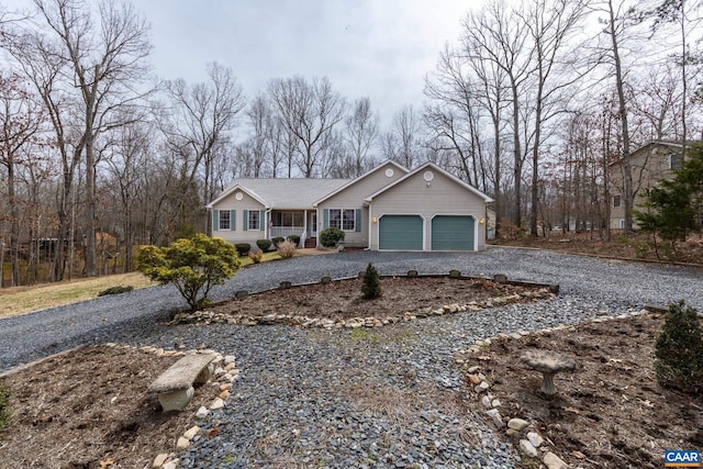 ranch-style house featuring an attached garage and gravel driveway