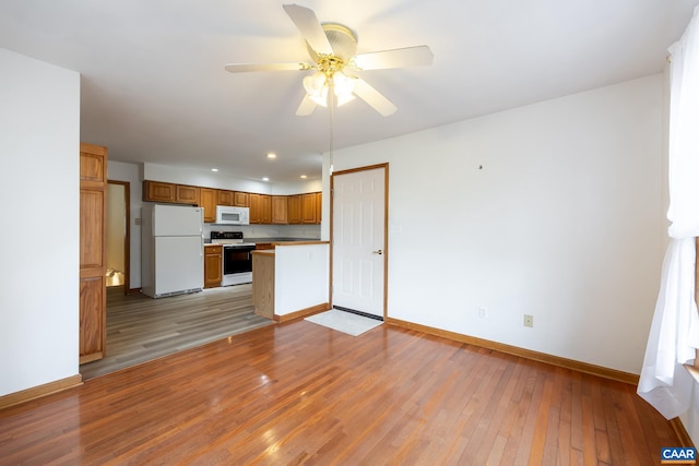 kitchen with white appliances, baseboards, ceiling fan, light wood-style floors, and brown cabinets