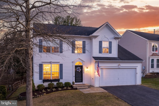 view of front of house featuring driveway, a shingled roof, and a front lawn