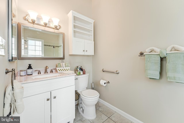 bathroom featuring toilet, vanity, and baseboards