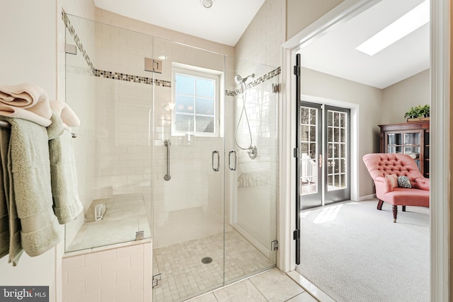 bathroom featuring tile patterned flooring, a stall shower, ensuite bathroom, and vaulted ceiling