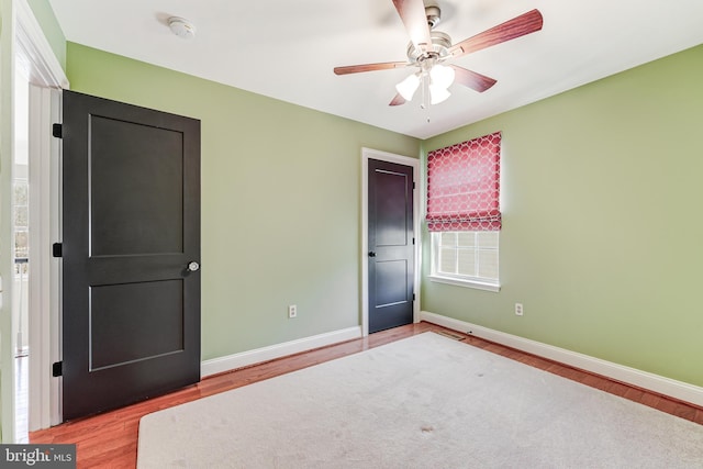 unfurnished bedroom featuring a ceiling fan, baseboards, and wood finished floors