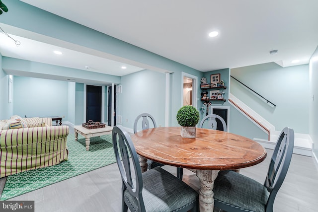 dining space with light wood-style flooring, recessed lighting, stairs, and baseboards