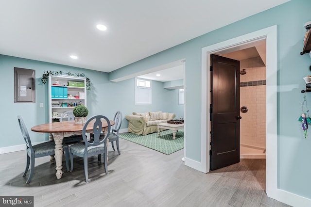 dining room with wood finish floors, baseboards, electric panel, and recessed lighting