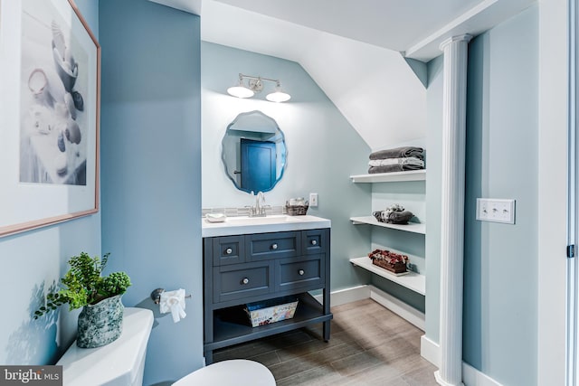 bathroom with baseboards, toilet, wood finished floors, and vanity