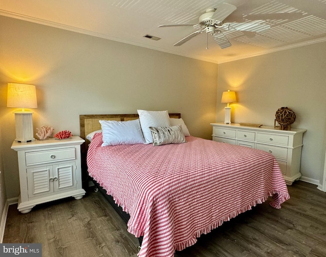 bedroom featuring dark wood-style floors, visible vents, and crown molding