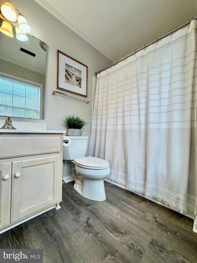 bathroom featuring wood finished floors, toilet, ornamental molding, and vanity