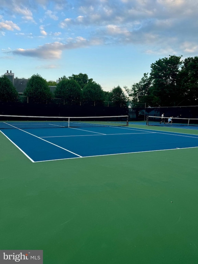 view of tennis court featuring fence