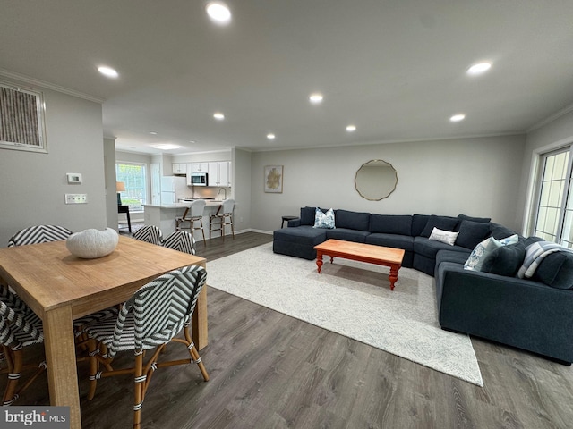 living area with dark wood finished floors, recessed lighting, baseboards, and ornamental molding