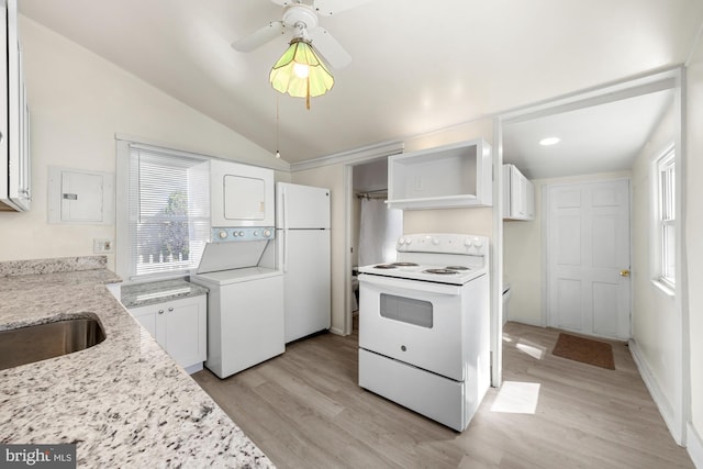 kitchen with light wood finished floors, light stone countertops, vaulted ceiling, white appliances, and stacked washer / drying machine