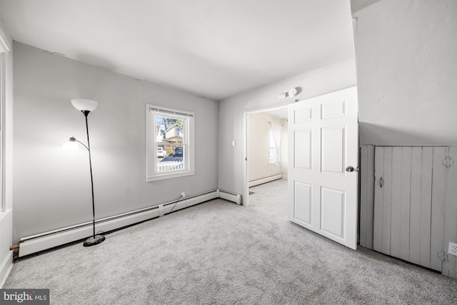 unfurnished bedroom with a baseboard heating unit and carpet