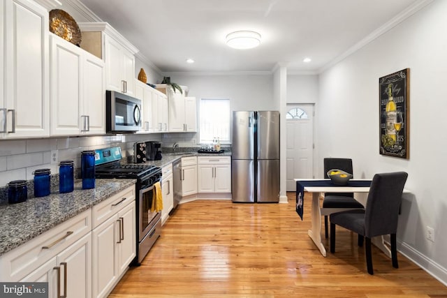 kitchen featuring backsplash, appliances with stainless steel finishes, and crown molding