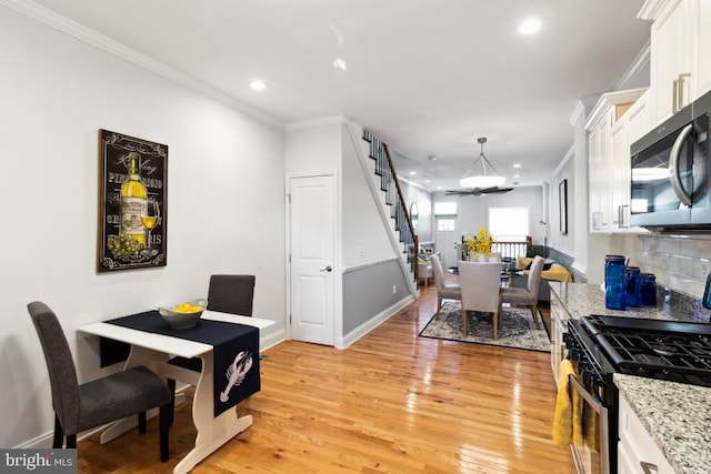 dining room featuring crown molding, baseboards, light wood-type flooring, recessed lighting, and an inviting chandelier