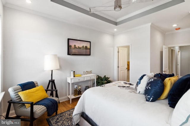 bedroom featuring crown molding, recessed lighting, wood finished floors, and a tray ceiling