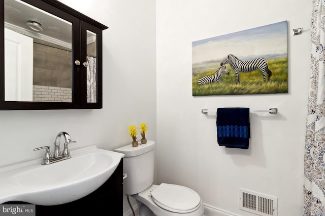 bathroom with vanity, toilet, and visible vents