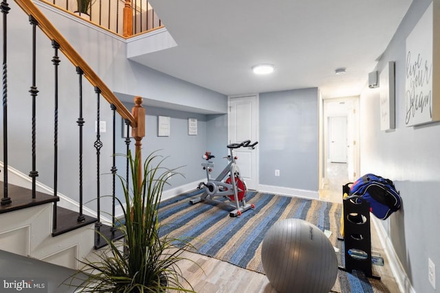 workout area with baseboards and wood finished floors