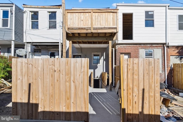 back of property with brick siding and fence