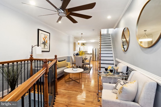 living area featuring light wood-style flooring, recessed lighting, a ceiling fan, and ornamental molding