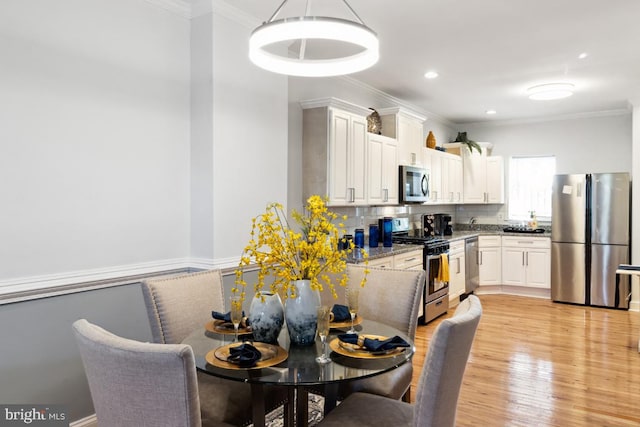 dining area with recessed lighting, light wood-style flooring, and ornamental molding