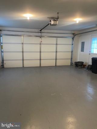 garage with electric panel and a garage door opener