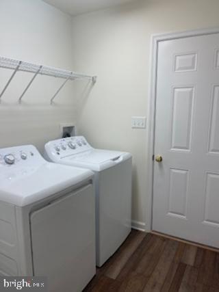 laundry area featuring laundry area, wood finished floors, and washing machine and clothes dryer