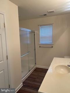 full bathroom with visible vents, a stall shower, wood finished floors, baseboards, and vanity