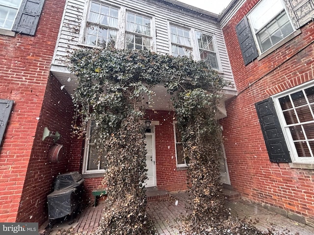 view of exterior entry featuring brick siding