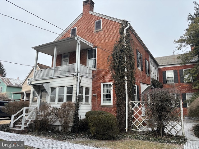 view of home's exterior featuring brick siding and a balcony