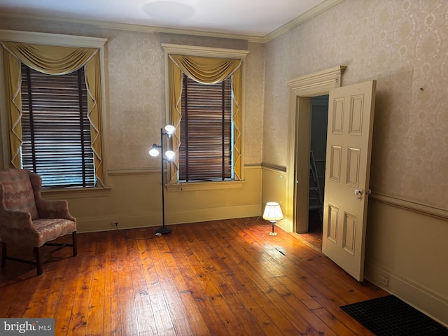 unfurnished room with crown molding, baseboards, and wood-type flooring