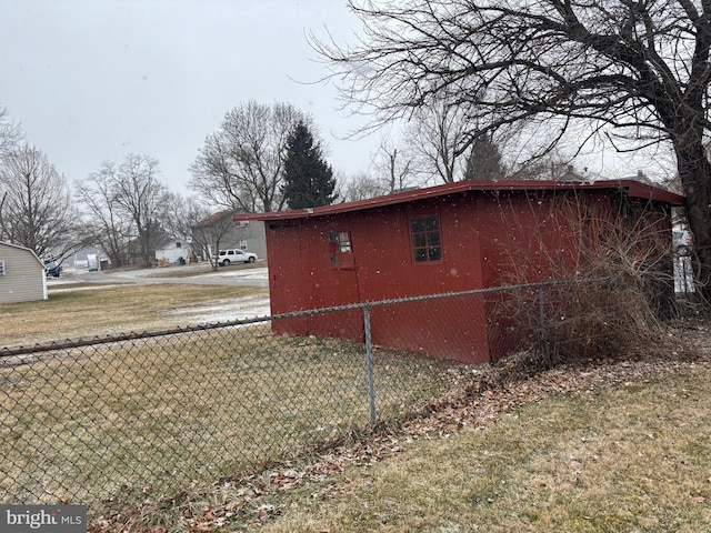 view of side of property with an outbuilding, a yard, and fence