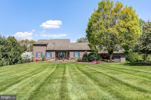 rear view of property with a lawn and stone siding