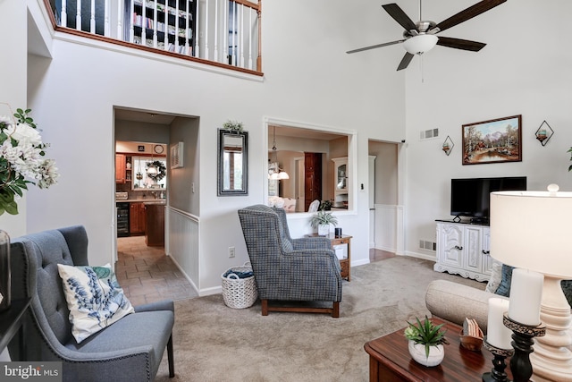 living room with visible vents, wine cooler, ceiling fan, and carpet flooring