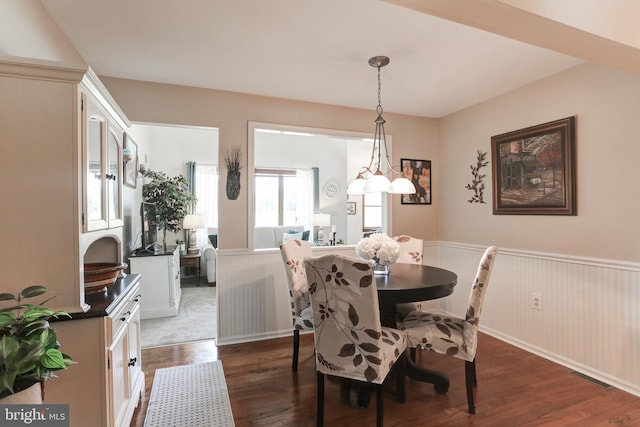 dining area featuring visible vents, dark wood-type flooring, and wainscoting