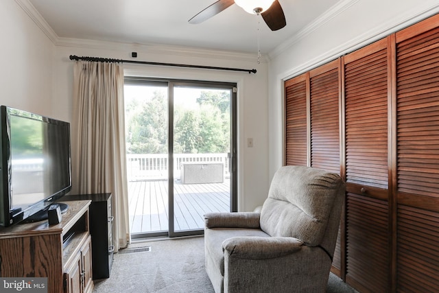 sitting room with crown molding, light colored carpet, visible vents, and ceiling fan