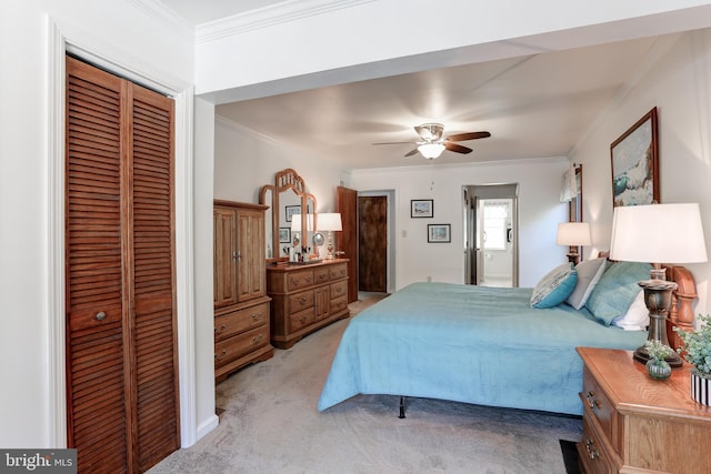 bedroom with ceiling fan, light colored carpet, a closet, and ornamental molding