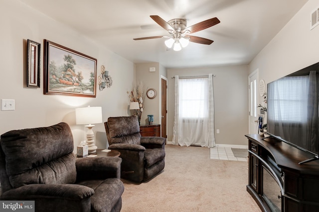 living room with visible vents, light carpet, baseboards, and a ceiling fan