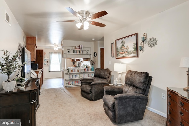 carpeted living area with visible vents, baseboards, and ceiling fan