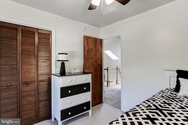 bedroom featuring a ceiling fan, light colored carpet, and a closet