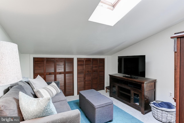 carpeted living room featuring lofted ceiling with skylight