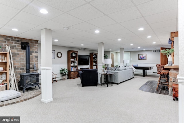 living area featuring recessed lighting, carpet, wainscoting, and a wood stove