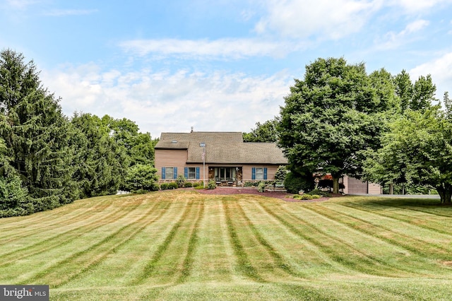 rear view of property with a yard