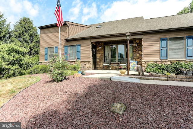 view of front of property with stone siding and a shingled roof