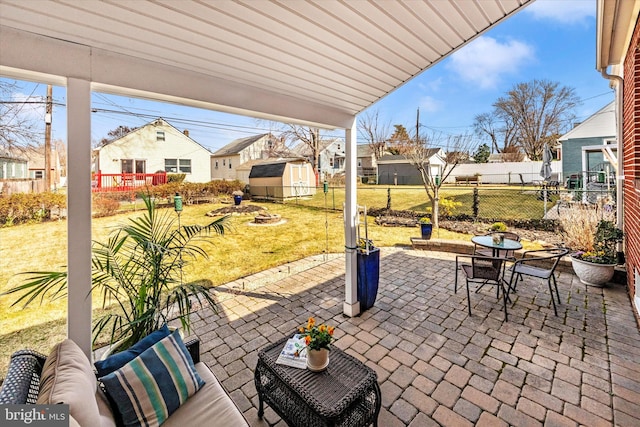 view of patio / terrace with an outbuilding, an outdoor living space, fence, a storage shed, and outdoor dining area